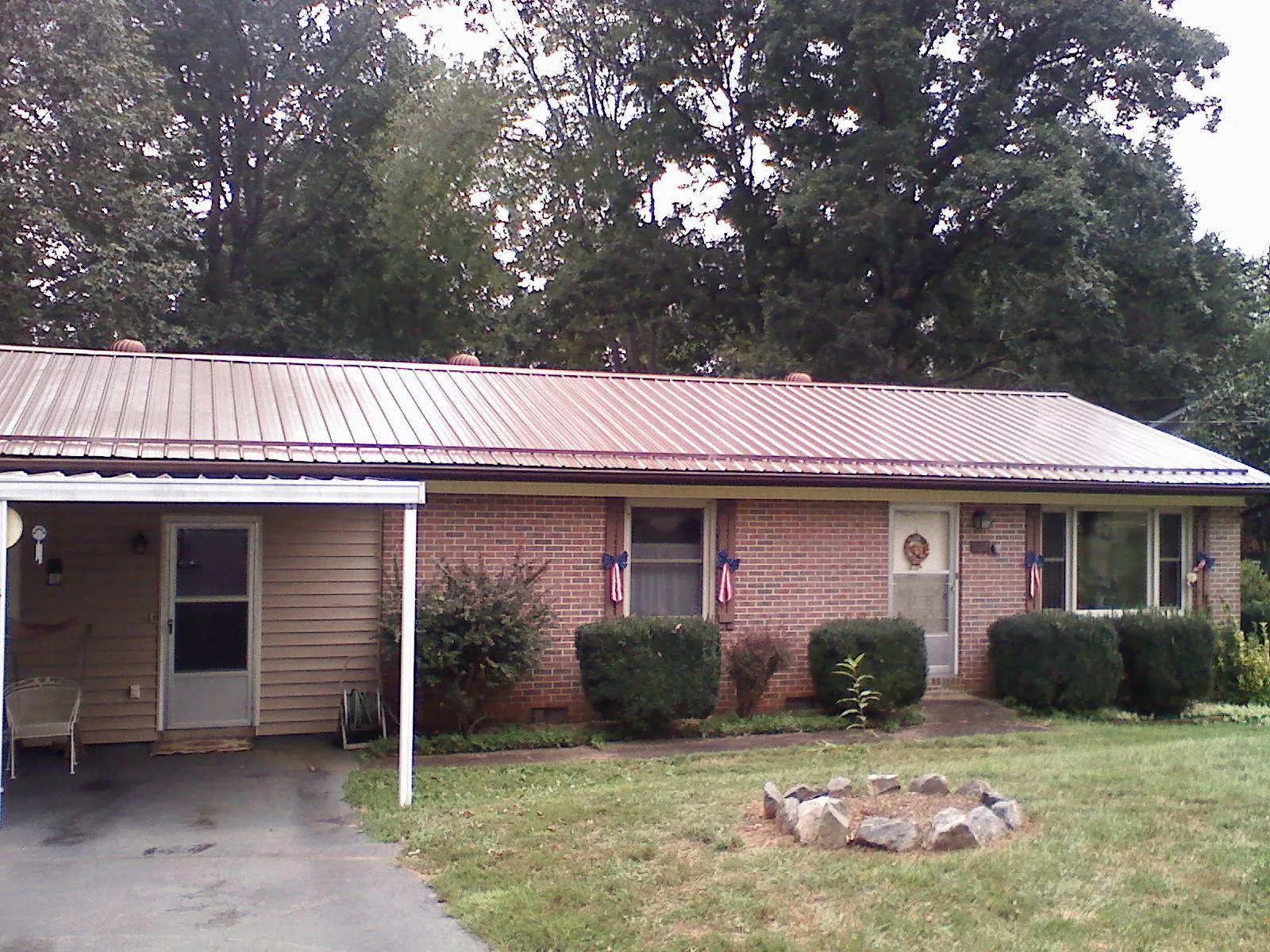 Bronze metal roof and carport on a brick ranch home — Roof Repair work by our crew in Jupiter